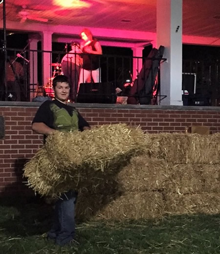 Steven picks up strawbales after the first concert of the new Downtown Concert Series